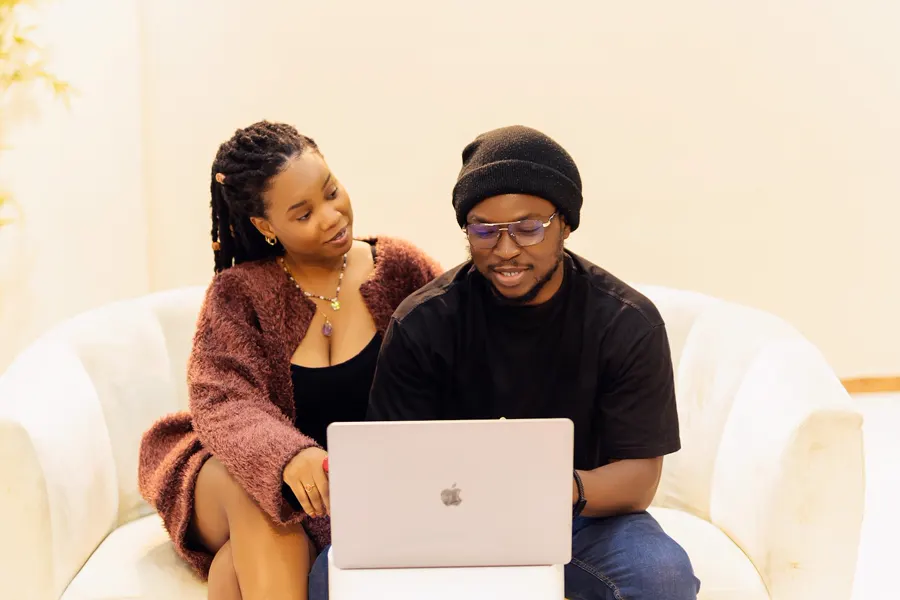Casal no sofá conferindo a proposta no notebook